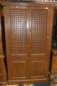 A modern mahogany cabinet with two latticework doors over two enclosed doors,