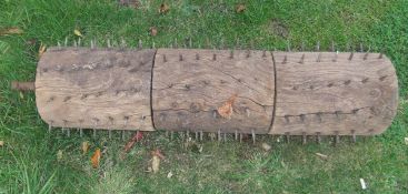 A spiked wooden lawn aerator (handles missing),