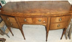 A Regency bow front mahogany sideboard of three drawers and cupboard door