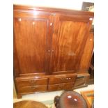 A 19th Century mahogany dwarf linen press with two cupboard doors over a bank of four drawers on