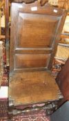 An oak hall chair with two panels to back with turned front stretcher to turned legs,