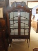 An Edwardian mahogany and inlaid two door display cabinet, the doors opening to reveal two shelves,