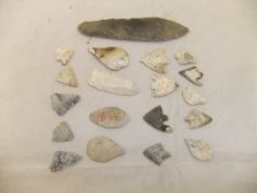 A tin containing a flint spear head, together with various flint and other stone arrow heads