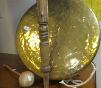 A large brass gong with wood and leather beater,