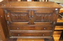 A Goodlys of Leicester oak sideboard with two cupboard doors with linen fold decoration and with