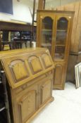 An oak bureau, the fall front above a single drawer over two cupboard doors,