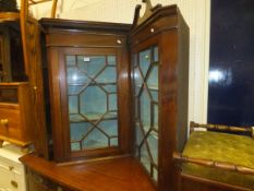 A mahogany single glazed door corner cupboard with various shelving,