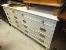 A modern white painted chest of eight various drawers