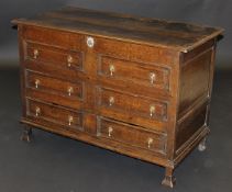 An 18th Century oak mule chest, the rising lid with moulded edge above four false drawers over two