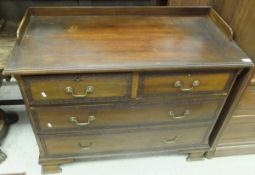 An Edwardian mahogany and blind fretwork decorated chest of two short over two long drawers on