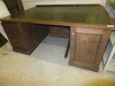 A large oak double pedestal desk with tooled and gilded leather insert writing surface over two