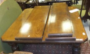 A late Victorian walnut extending dining table, the plain top with moulded edge and canted corners,