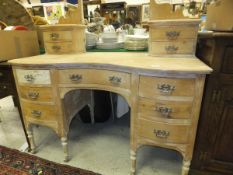 An Edwardian pine kidney shaped dressing table with two banks of three drawers and central frieze
