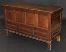 An early 18th Century coffer, the plank top with moulded edge above four holly strung fielded panels