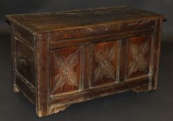 An early 17th Century oak coffer, the two plank top with moulded edge above a moulded frieze & three