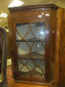 A mahogany wall hanging corner cabinet with astragal glazed doors and inlaid decoration