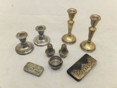 A collection of silver wares to include two pairs of candlesticks, a three piece cruet,