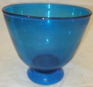 A large blue glass footed bowl with a rough ground out pontil mark to base