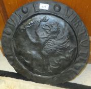 An Arts and Crafts style pewter charger with central gryphon embossed decoration, the border with