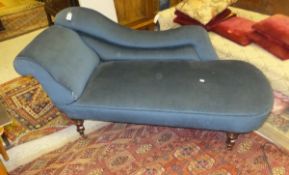 A Victorian chaise longue raised on mahogany turned and ringed legs to brass caps and castors,