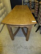 A pine refectory style table on square supports united by twin curved stretchers