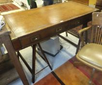 A modern teak campaign style trestle desk with leather insert writing surface and brass flush