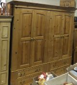 A large pine wardrobe with four doors above four short drawers,