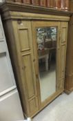 A pine single mirrored door wardrobe of small proportions,