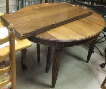 An oak oval draw leaf dining table, with two extra leaves,