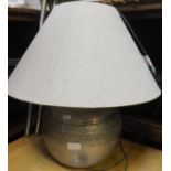 A metal table lamp with hessian type shade
