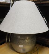 A metal table lamp with hessian type shade