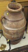 A Greek terracotta amphora with two ribbed bands united by the side handles over a plain body,