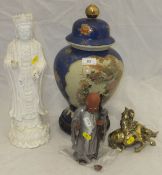 A blanc-de-chine figure of a deity, a Japanese vase and cover raised on wooden base, an Oriental