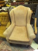An early 20th Century wing back armchair with peach upholstery