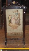 A 19th Century rosewood framed fire screen with petit point needlework decoration of figures with