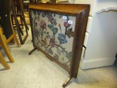 A 19th Century rosewood framed fire screen with long stitch panel depicting flowers and parrot