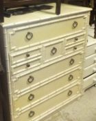 A white and green decorated chest of assorted drawers with bamboo decoration