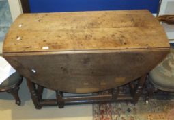 An oak drop leaf dining table in the early 18th Century manner