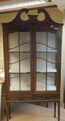 An Edwardian mahogany and inlaid two door display cabinet, the doors opening to reveal two shelves,