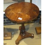 A rosewood circular centre table on turned baluster shaped column to triform base