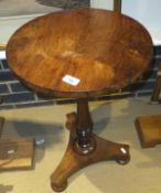 A rosewood circular centre table on turned baluster shaped column to triform base