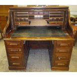 A circa 1900 mahogany tambour top desk "The Arvon" with basic fitted interior over two banks of