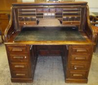 A circa 1900 mahogany tambour top desk "The Arvon" with basic fitted interior over two banks of