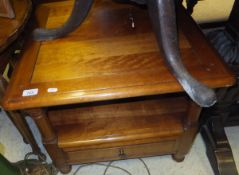 A modern cherrywood two tier square table with single drawer on turned supports