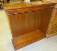 A yew wood open bookcase of adjustable shelves on a plinth base and brass bedstead