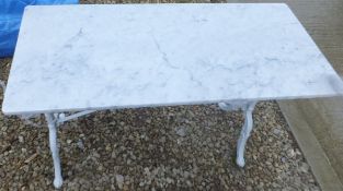 A white marble topped rectangular table with painted wrought iron base
