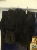 A large collection of gentleman's suits to include evening tails, waistcoats, etc.