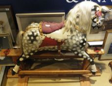 An early to mid 20th Century dapple painted rocking horse on wooden base