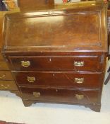 A mahogany three drawer bureau on bracket feet with brass handles and escutcheons