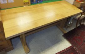 A rectangular oak dining table on trestle style supports